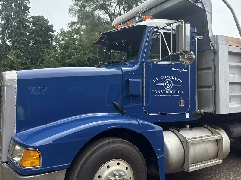 CV Concrete Construction blue dump truck parked on a job site