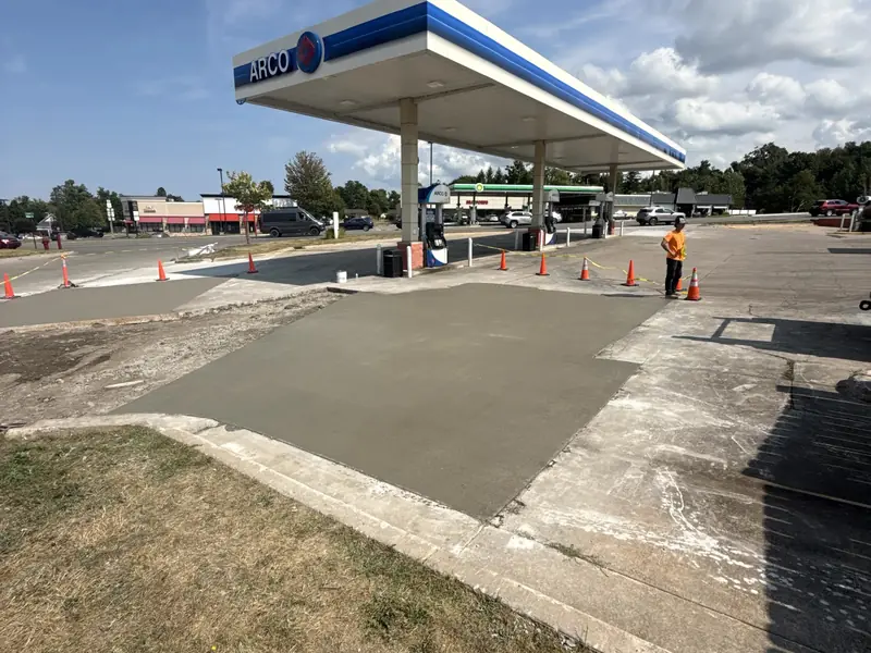 Fresh concrete approach and curb poured at a gas station forecourt