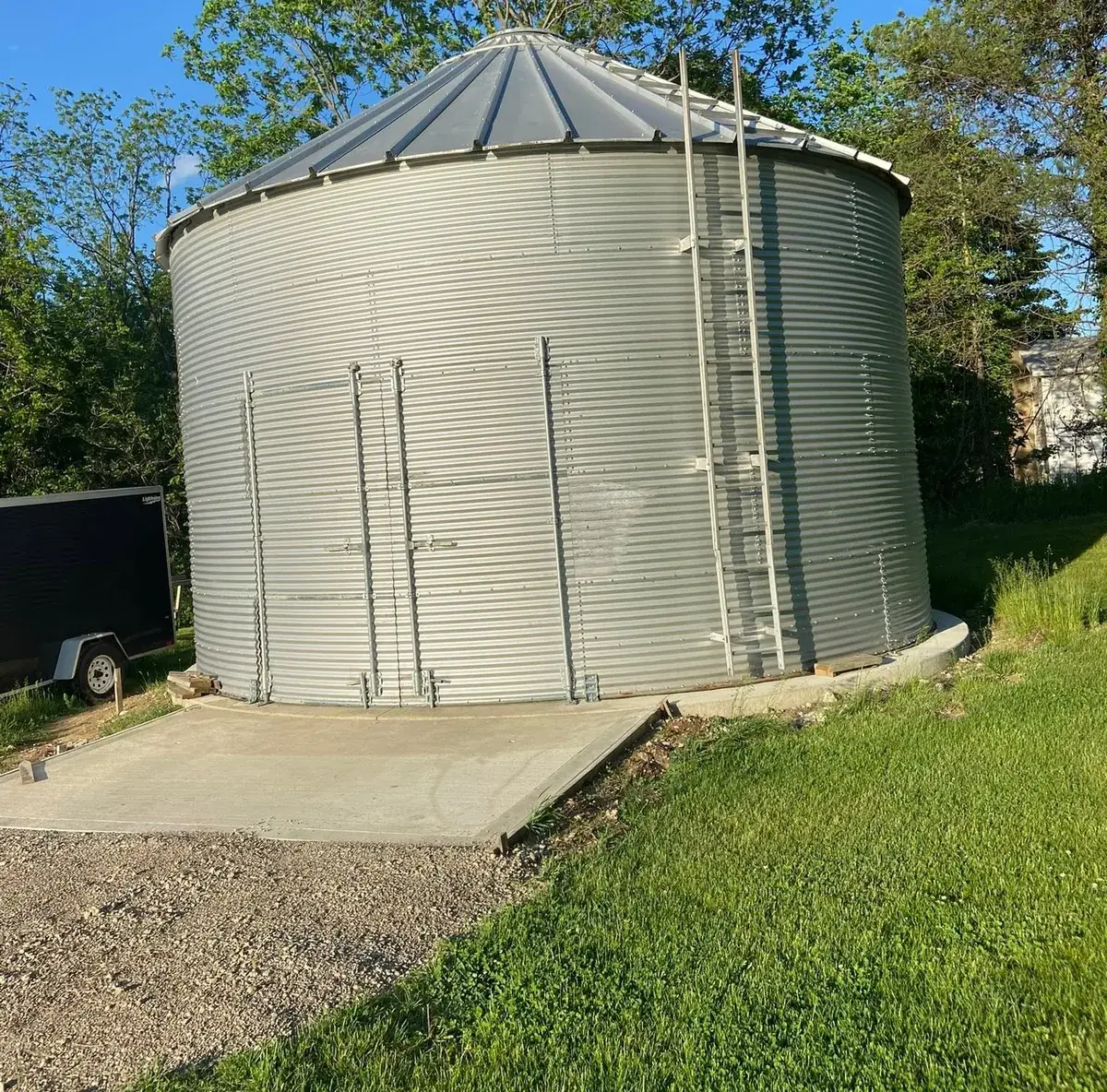 Grain bin standing on a new poured concrete base pad